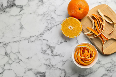 Orange fruits with peels on white marble table, flat lay. Space for textの写真素材