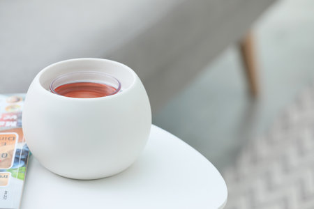 Wax air freshener and magazine on white table indoors, space for text. Interior elementsの写真素材