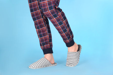 Man in warm soft slippers on light blue background, closeupの写真素材