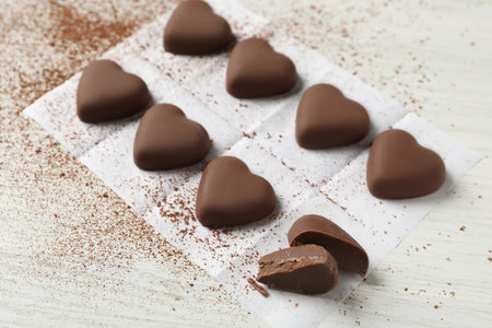 Beautiful heart shaped chocolate candies on white wooden tableの写真素材