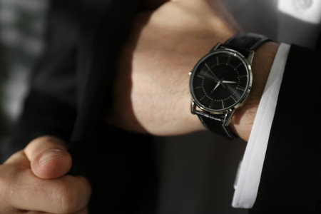 Businessman with luxury wrist watch on blurred background, closeupの写真素材