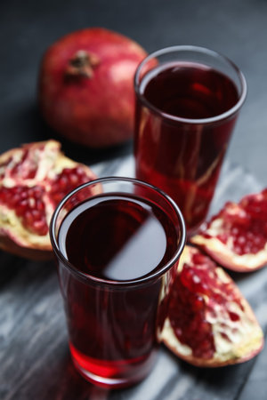 Pomegranate juice and fresh fruits on dark tableの写真素材