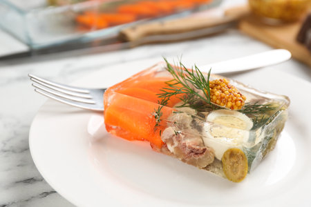 Delicious aspic with meat and vegetables served on white marble table, closeupの写真素材