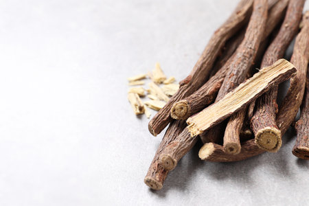 Dried sticks of liquorice root on grey table, closeup. Space for textの写真素材
