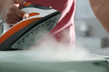 Man ironing clean shirt at home, closeupの写真素材
