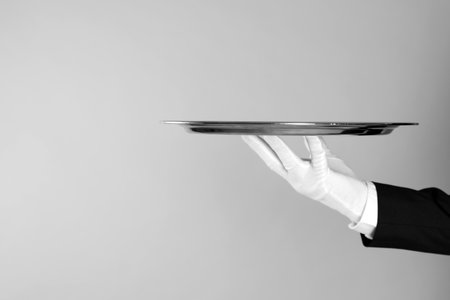 Butler with tray on light gray background, closeup. Space for textの写真素材