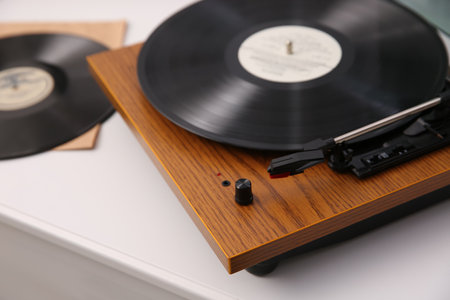 Stylish turntable with vinyl record on white chest of drawers, closeupの写真素材