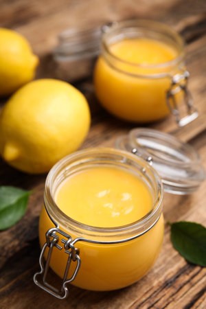 Delicious lemon curd in glass jar on wooden tableの写真素材