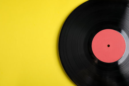 Vintage vinyl record on yellow background, top view. Space for textの写真素材