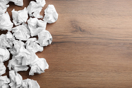 Crumpled sheets of paper on wooden background, flat lay. Space for textの写真素材