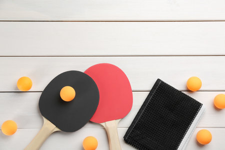 table tennis  rackets, net and balls on white wooden table, flat lay. Space for textの写真素材