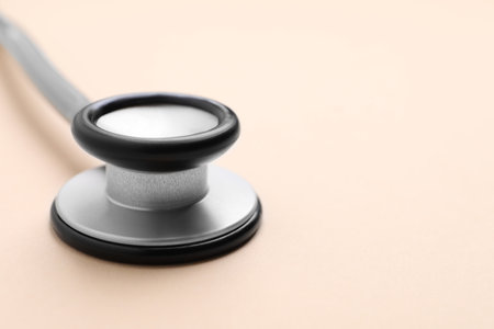 Stethoscope on beige background, closeup. Space for textの写真素材
