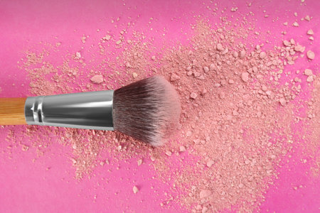 Makeup brush and scattered blush on bright pink background, top viewの写真素材