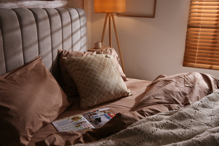 Bed with stylish linen and soft pillows in the roomの写真素材