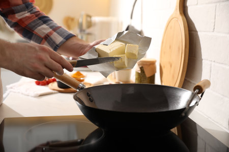 Man putting butter into frying pan, closeupの写真素材
