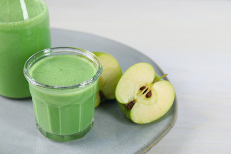 Tasty fresh apple smoothie on white table, space for textの写真素材