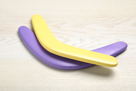 Color boomerangs on white wooden background. outdoor activityの写真素材