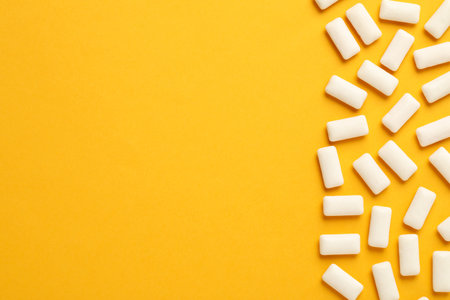 Many chewing gum pieces on orange background, flat lay. Space for textの写真素材