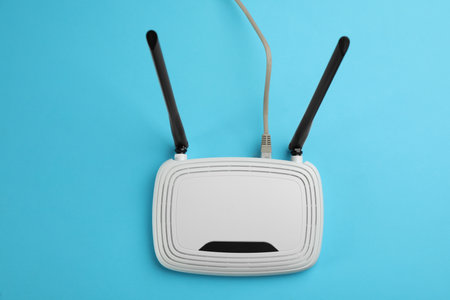 Modern WiFi router on light blue background, top viewの写真素材