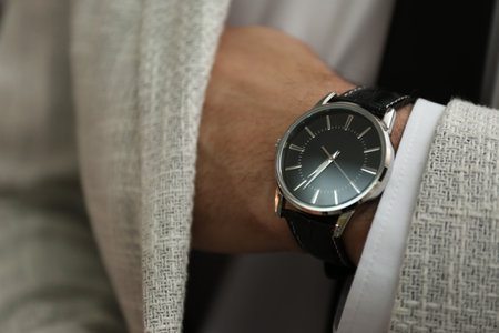 Businessman in jacket with luxury wrist watch, closeup