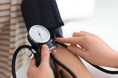 Doctor checking blood pressure of woman in clinic, closeupの写真素材