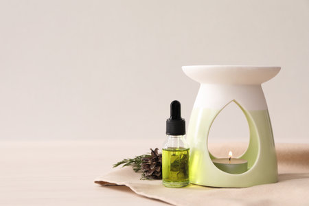 Aroma lamp with coniferous essential oil on white wooden table, space for textの写真素材