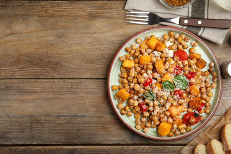 Delicious fresh chickpea salad served on wooden table, flat lay. Space for textの写真素材