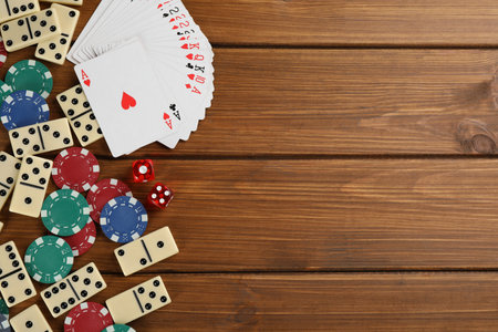 Elements of different board games on wooden table, flat lay. Space for textの写真素材