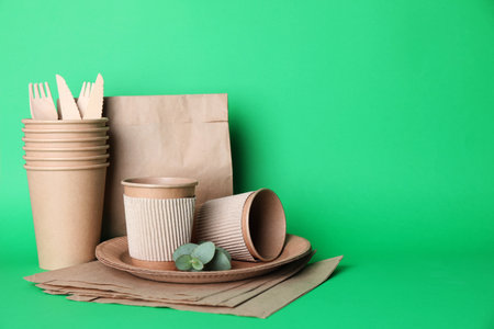 Set of disposable eco friendly dishware on green backgroundの写真素材