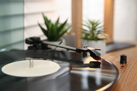 Stylish turntable with vinyl record on wooden table indoors, closeupの写真素材