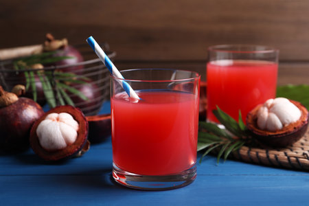 Delicious fresh mangosteen juice on blue wooden tableの写真素材