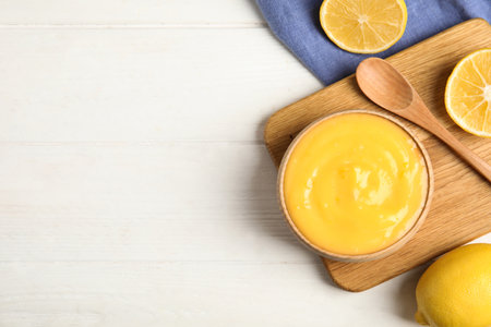 Delicious lemon curd and fresh fruits on white wooden table, flat lay. Space for textの写真素材