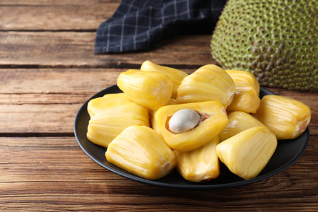 Fresh exotic jackfruit bulbs on wooden tableの写真素材