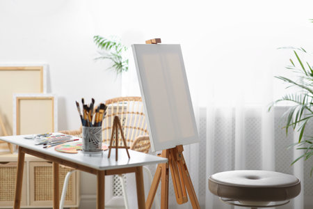 Table with paints and tools near easel in art studioの素材 [FY310201633898]