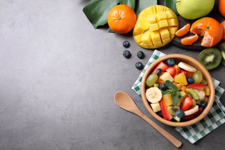 Delicious fruit salad on gray table, flat lay. Space for textの写真素材