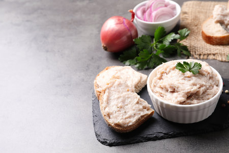 Delicious lard spread in bowl and sandwich on gray table. Space for textの写真素材