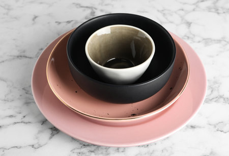 Stack of clean dishes on white marble tableの写真素材