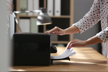 Employee using modern printer in office, closeupの写真素材