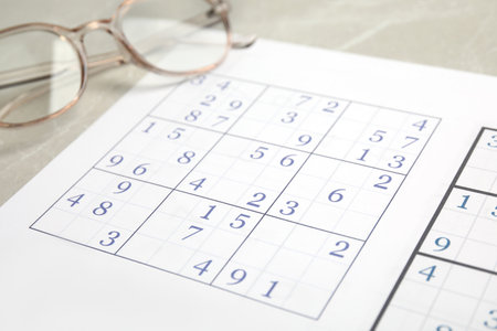 Sudoku and eyeglasses on table, closeup viewの写真素材