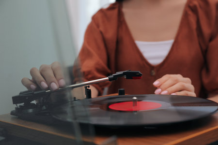 Woman using turntable at home, closeup viewの写真素材