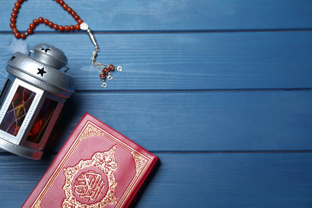 Arabic lantern, quran and misbaha on blue wooden table, flat lay. Space for textの写真素材