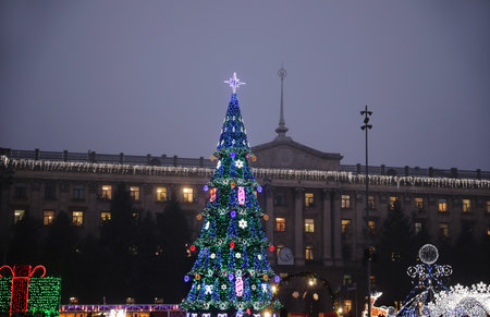 Beautiful decorated Christmas tree near building outdoors in the eveningの写真素材