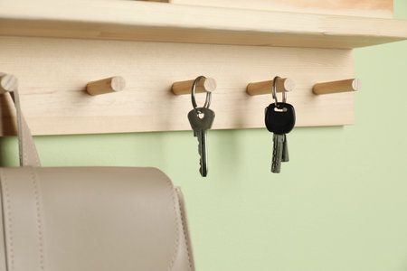 Wooden hanger for keys on light green wall