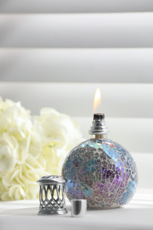 Burning catalytic purifying lamp and flowers on window sill. Interior elementの写真素材