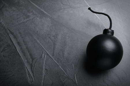Sphere shaped bomb with burning fuse on black background, top view. Space for textの写真素材