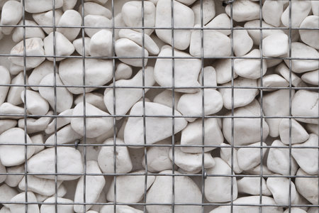 Beautiful white stones inside metal mesh as backgroundの写真素材