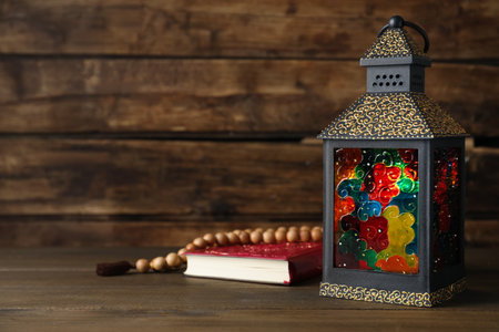 Decorative Arabic lantern, Quran and prayer beads on wooden table. Space for textの写真素材