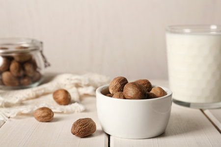 Nutmegs in bowl on white wooden tableの写真素材