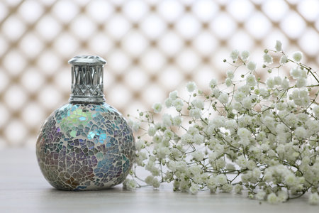 Beautiful catalytic purifying lamp and flowers on table. Interior elementの写真素材