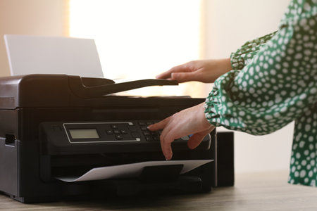 Woman using modern printer in office, closeupの写真素材